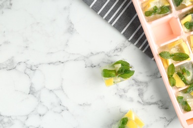 Flat lay composition with ice cube tray and space for text on marble table