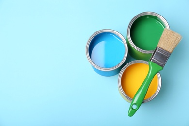 Photo of Flat lay composition with paint cans and brush on color background. Space for text