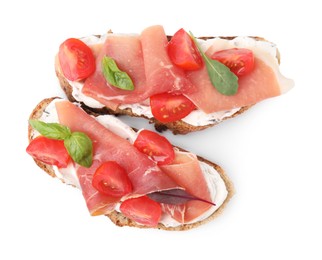 Tasty bruschettas with prosciutto, tomatoes and cheese on white background, top view