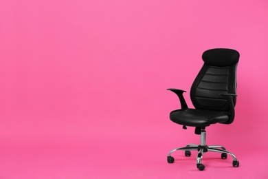 Photo of Comfortable office chair on pink background, space for text