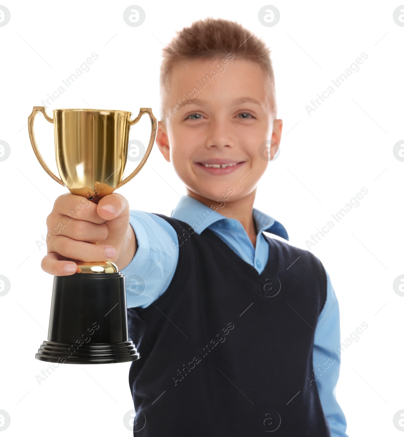 Photo of Happy boy in school uniform with golden winning cup isolated on white