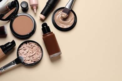 Photo of Liquid foundations, beauty accessories and face powders on beige background, flat lay. Space for text