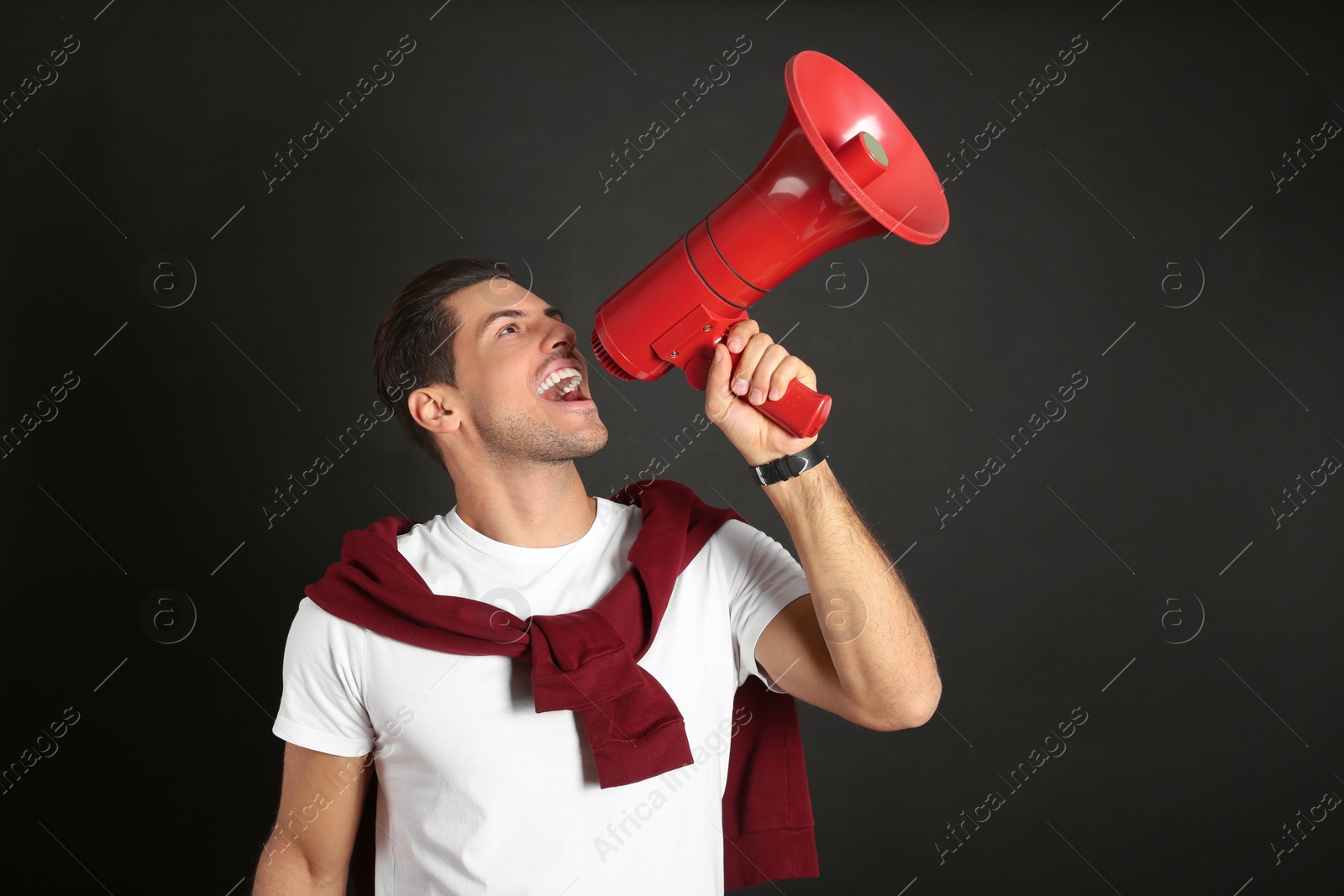 Photo of Handsome man with megaphone on black background