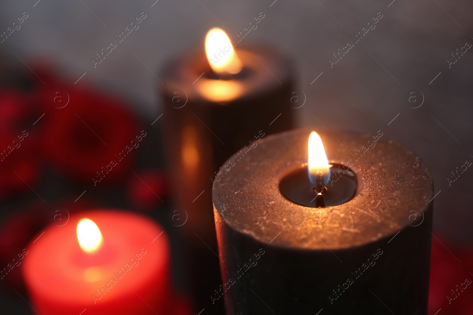 Photo of Burning black and red candles, closeup view