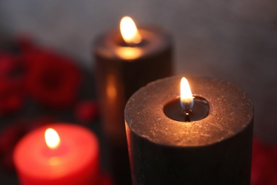 Photo of Burning black and red candles, closeup view