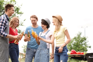 Young people having barbecue with modern grill outdoors