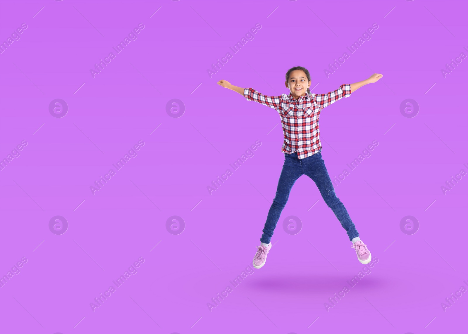 Image of Cute girl jumping on violet background, space for text