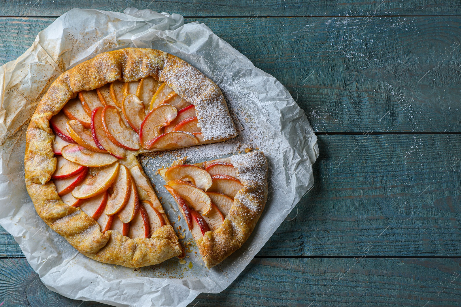 Photo of Delicious apple galette on wooden table, top view. Space for text