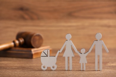 Photo of Family law. Figure of parents with children and gavel on wooden table, space for text