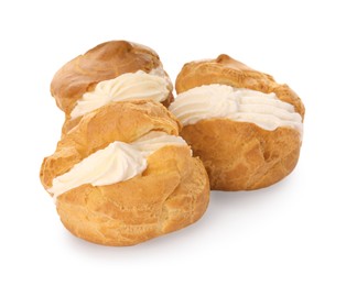 Photo of Delicious profiteroles with cream filling on white background