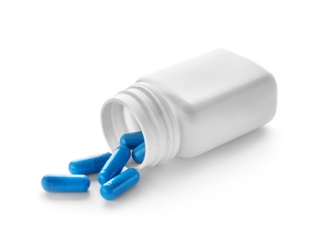 Photo of Container with blue capsules on white background