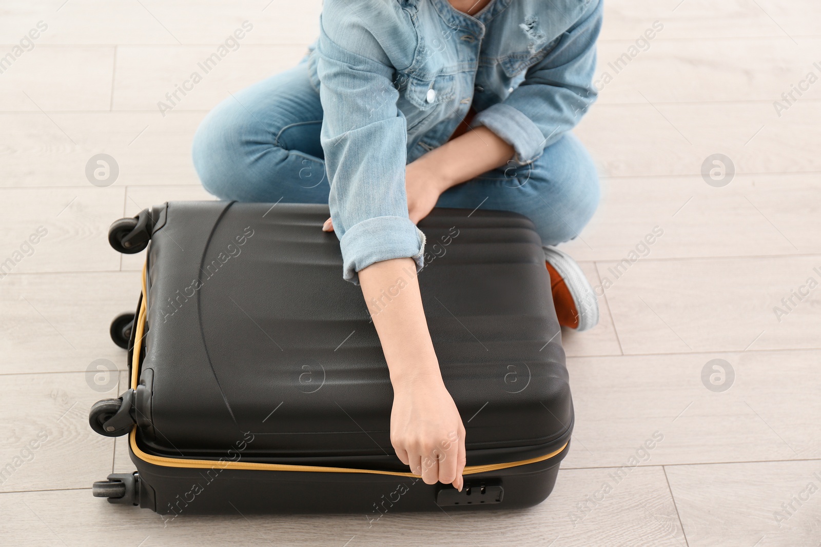 Photo of Young woman with suitcase indoors