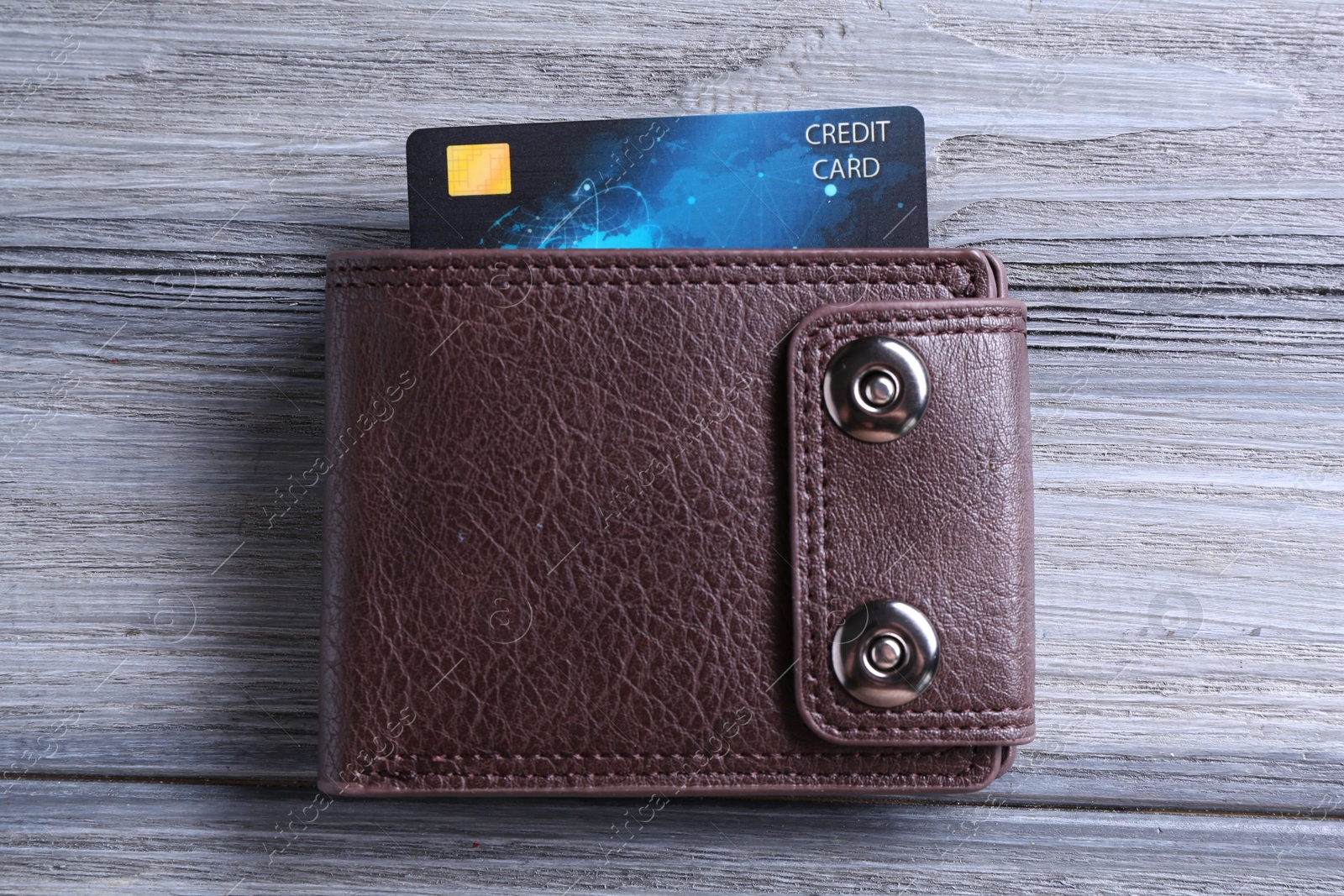 Photo of Credit card in leather wallet on grey wooden table, top view