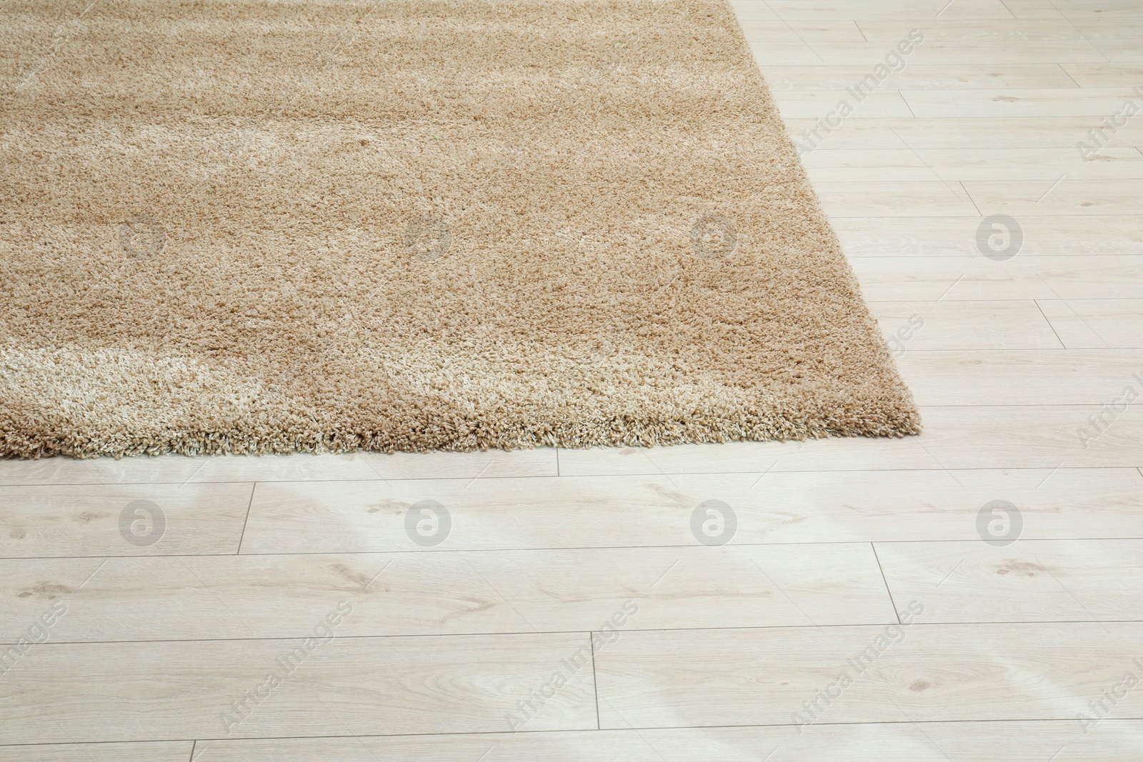 Photo of Soft beige carpet on white laminated floor indoors, space for text