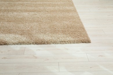 Photo of Soft beige carpet on white laminated floor indoors, space for text