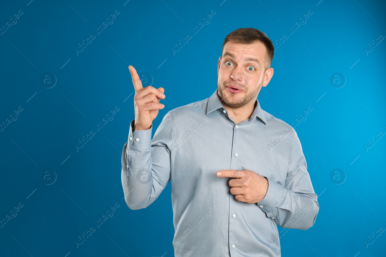 Photo of Portrait of emotional young man on blue background