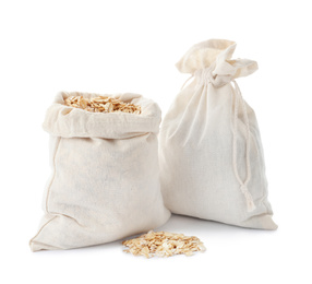 Photo of Cotton eco bags with oat flakes isolated on white