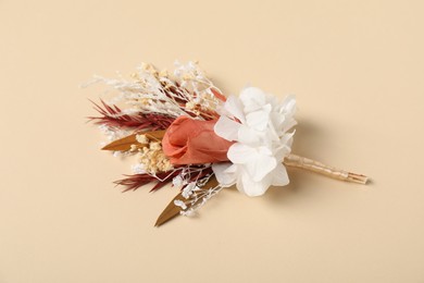 Photo of Stylish boutonniere on beige background, top view