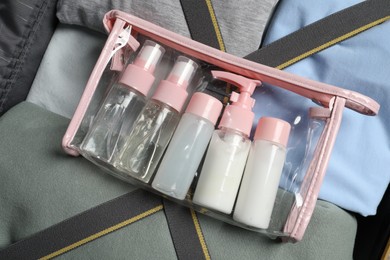 Photo of Plastic bag of cosmetic travel kit in suitcase, top view