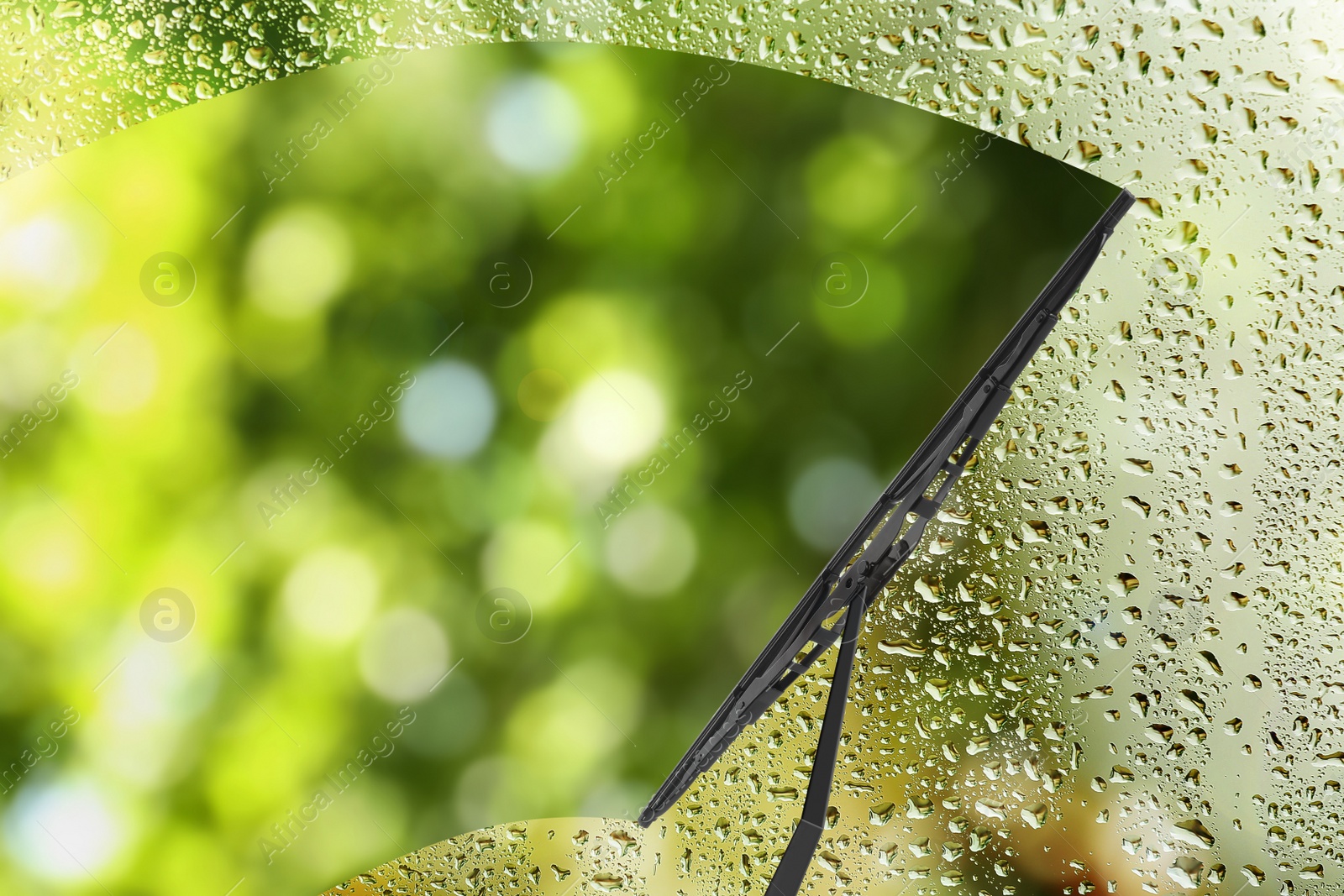 Image of Car windshield wiper cleaning water drops from glass