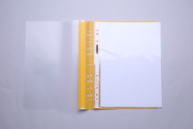 Photo of File folder with punched pockets and paper sheets on light grey background, top view