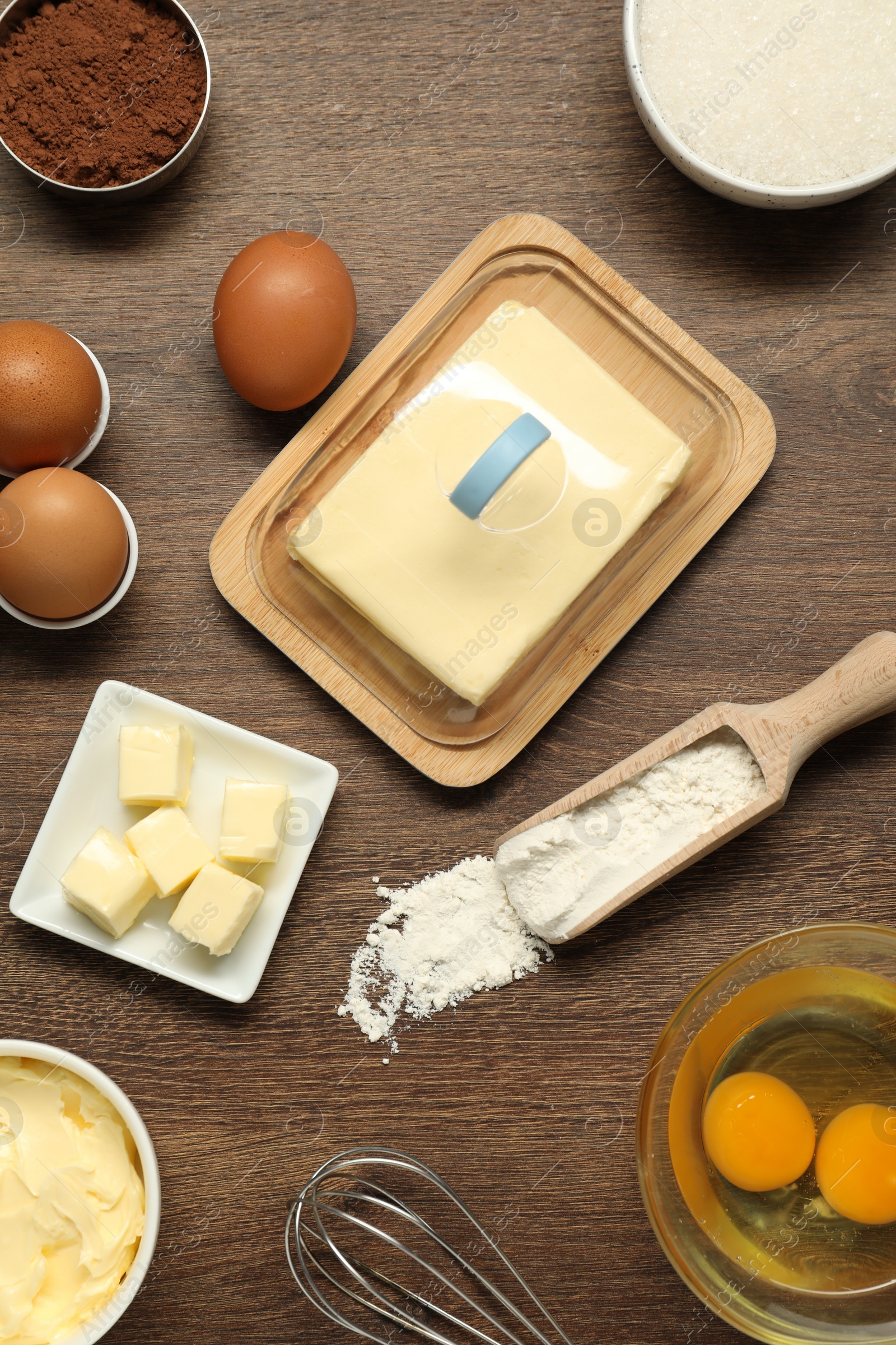 Photo of Flat lay composition with fresh butter among other products on wooden table