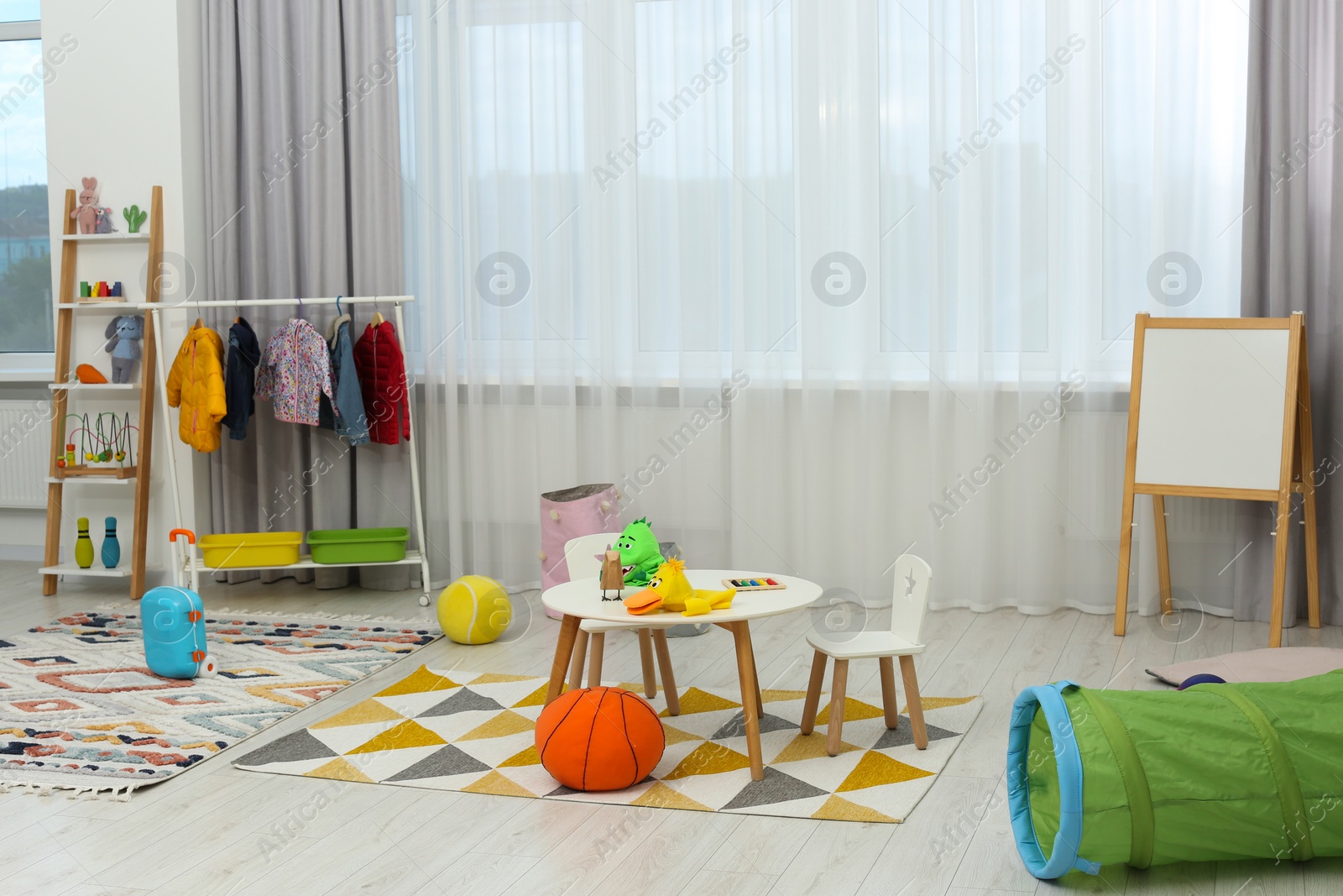 Photo of Child`s playroom with different toys and modern furniture. Stylish kindergarten interior