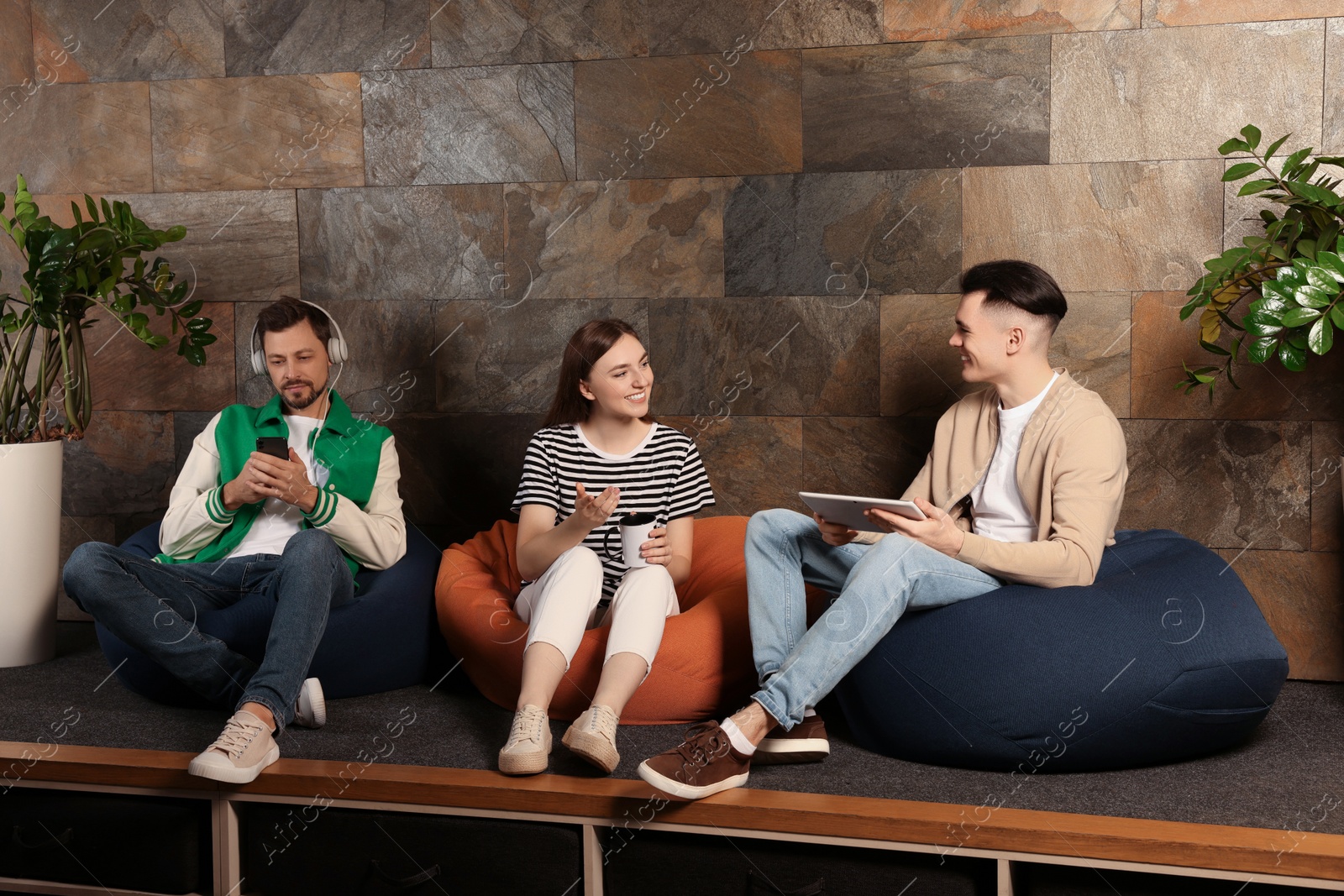 Photo of Office employees enjoying break together in recreation room at work