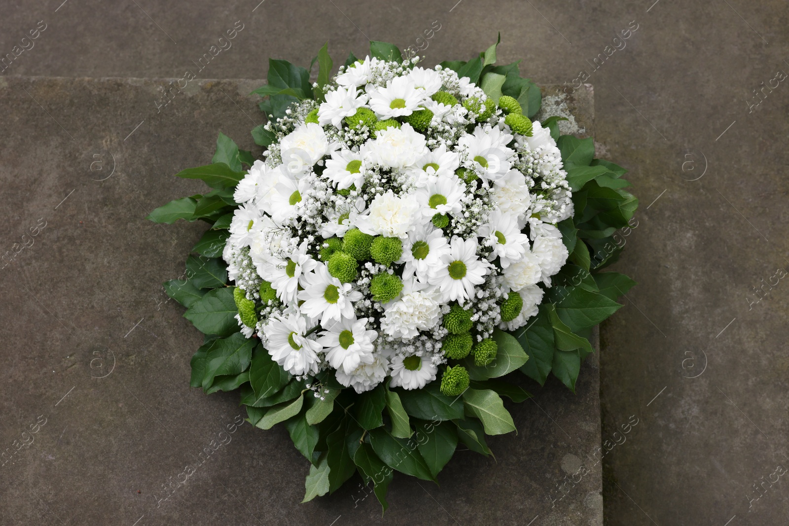 Photo of Funeral wreath of flowers on tombstone, above view