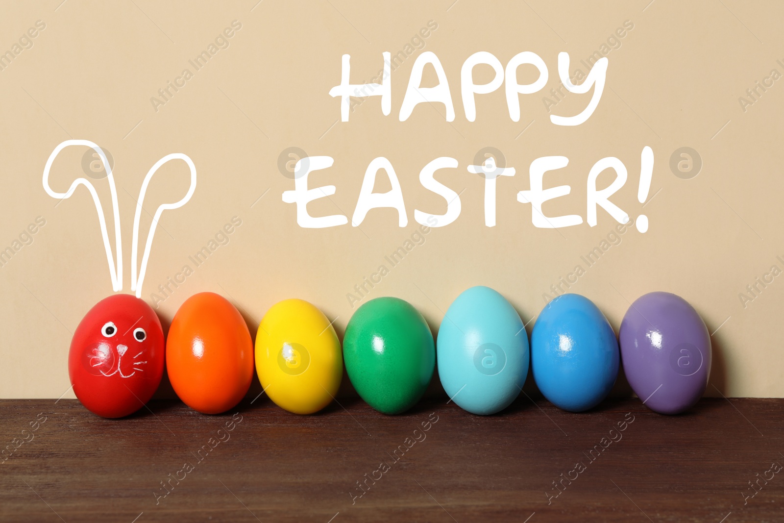 Image of Red egg with drawn face and ears as Easter bunny among others on wooden table against beige background