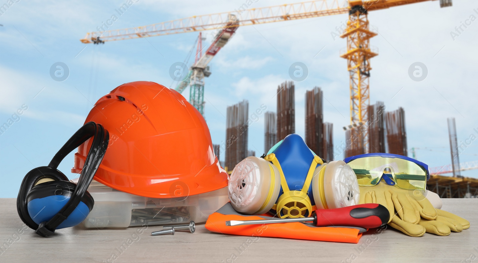 Image of Safety equipment and tools on wooden surface and blurred view of construction site. Banner design