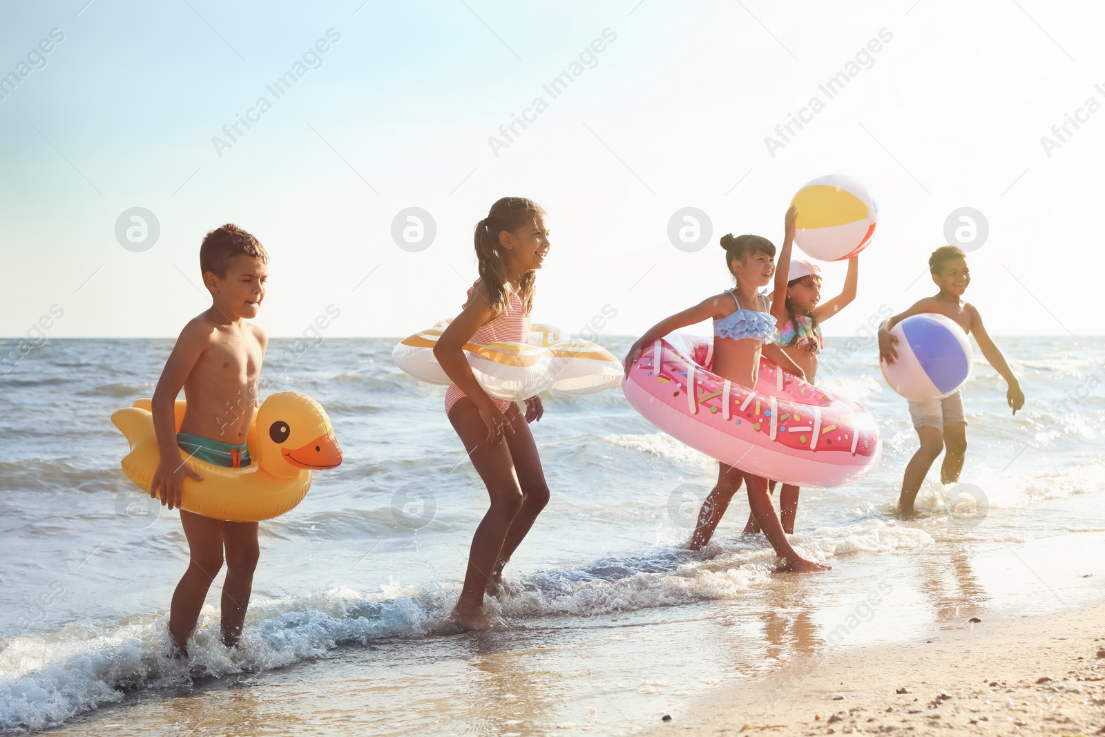 Photo of Cute children enjoying sunny day at beach. Summer camp