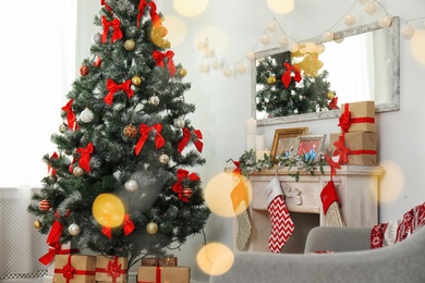 Stylish living room interior with decorated Christmas tree and blurred lights in foreground