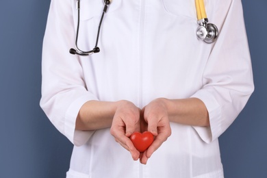 Doctor holding small heart, closeup. Prevent heart attack