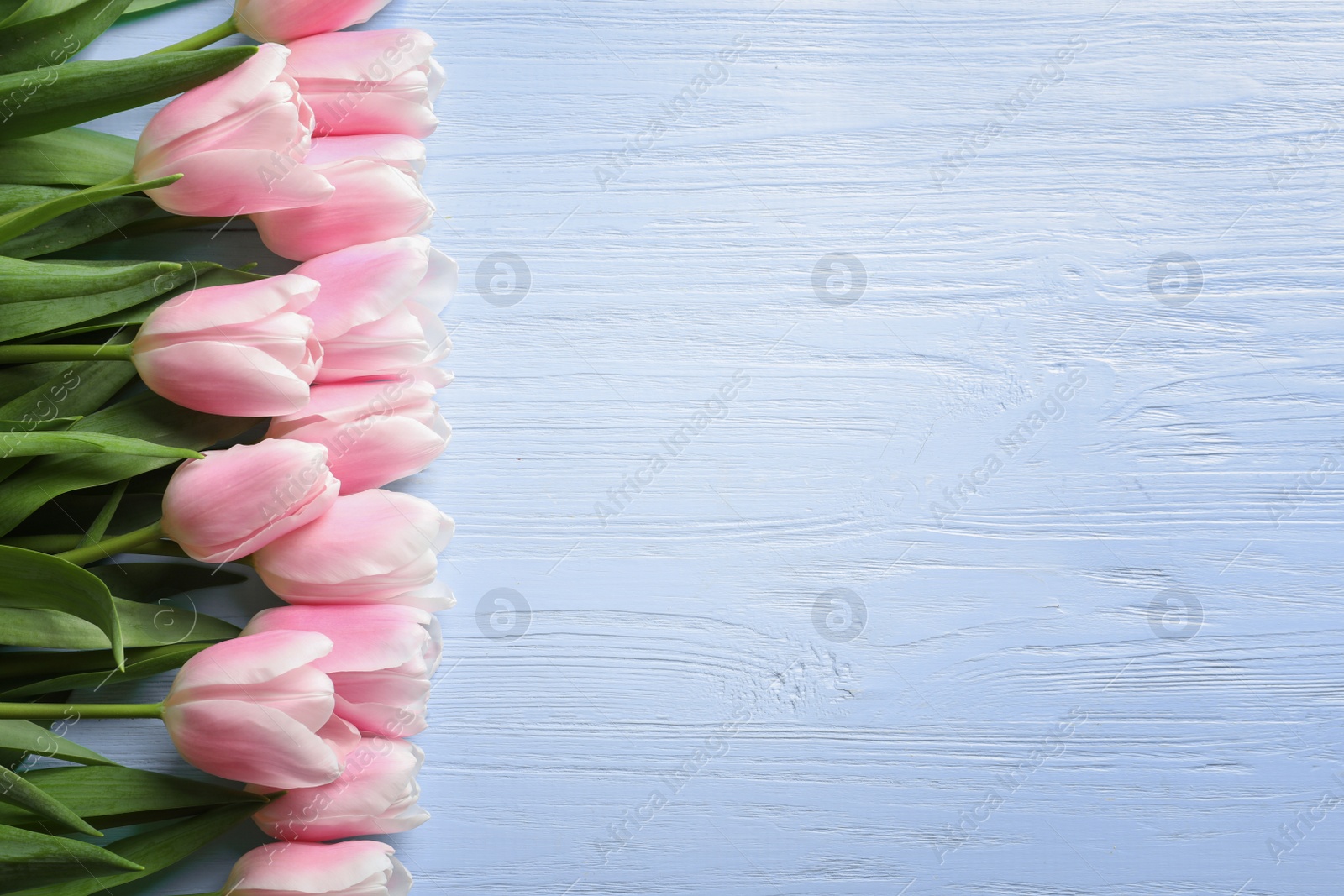 Photo of Beautiful tulips for Mother's Day on wooden background, top view