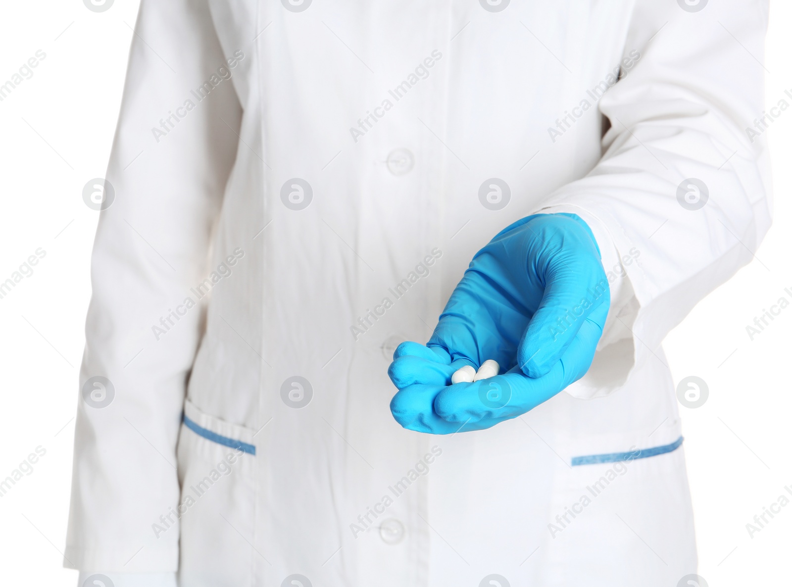 Photo of Doctor in medical glove holding pills on white background