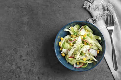 Photo of Flat lay composition with healthy cabbage salad on dark table