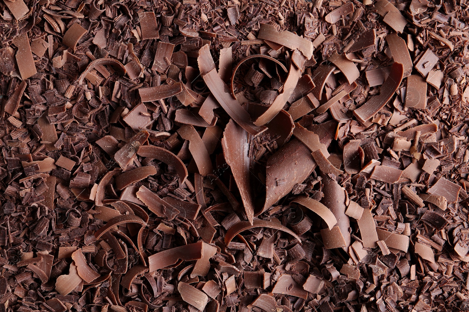 Photo of Yummy chocolate curls for decor as background, top view