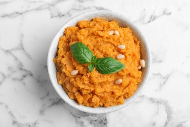 Bowl of tasty sweet potato puree on marble table, top view