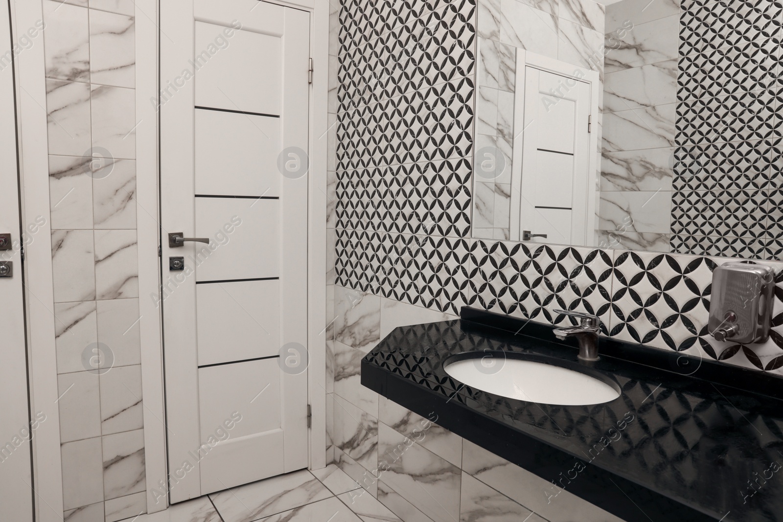 Photo of Public toilet interior with stylish white tiles