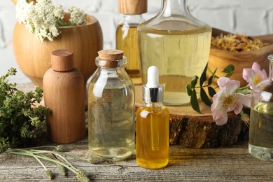 Photo of Aromatherapy. Different essential oils, herbs and flowers on wooden table