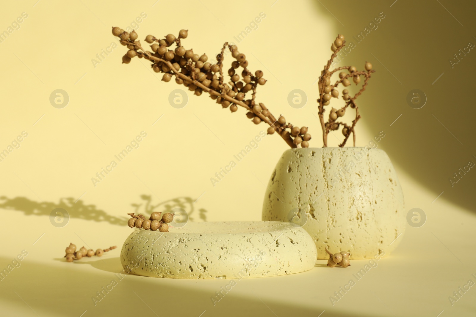 Photo of Presentation of product. Stone podium and vase with beautiful branches on yellow background