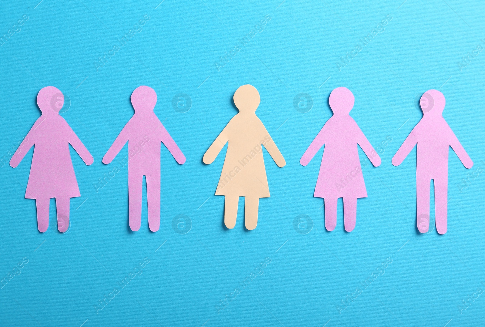 Photo of Many different paper human figures on light blue background, flat lay. Diversity and inclusion concept