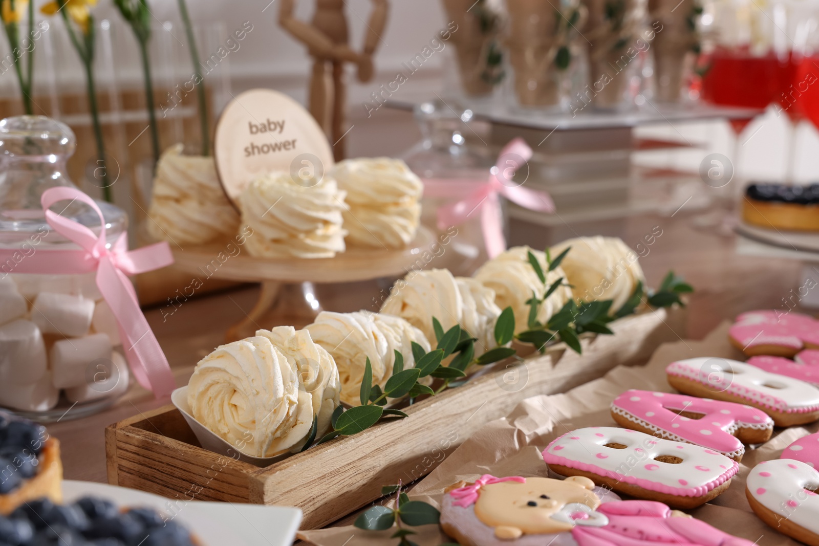 Photo of Baby shower party. Different delicious treats on wooden table indoors