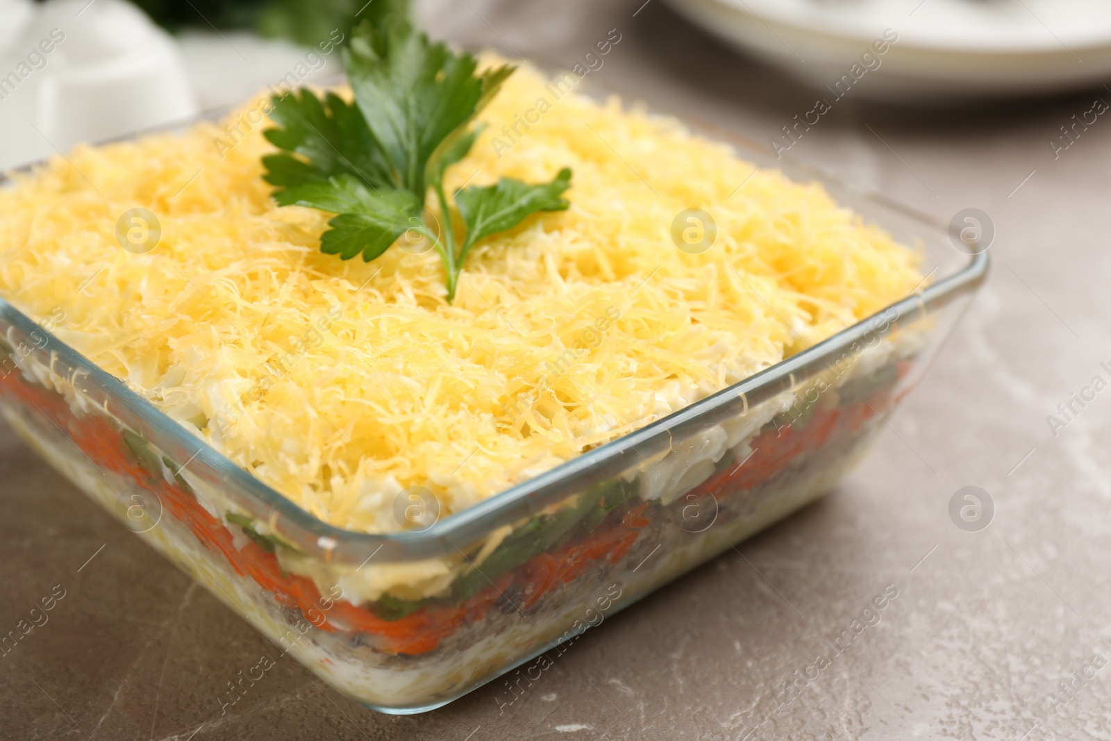 Photo of Traditional russian salad Mimosa served on marble table, closeup