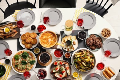 Photo of Brunch table setting with different delicious food and chairs indoors, top view