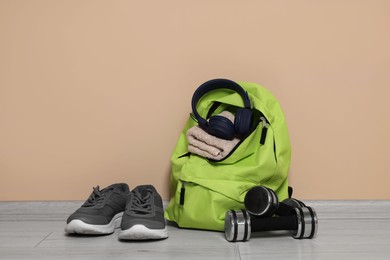 Photo of Backpack and sports equipment on floor near beige wall