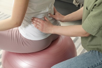 Photo of Doula massaging pregnant woman at home, closeup. Preparation for child birth
