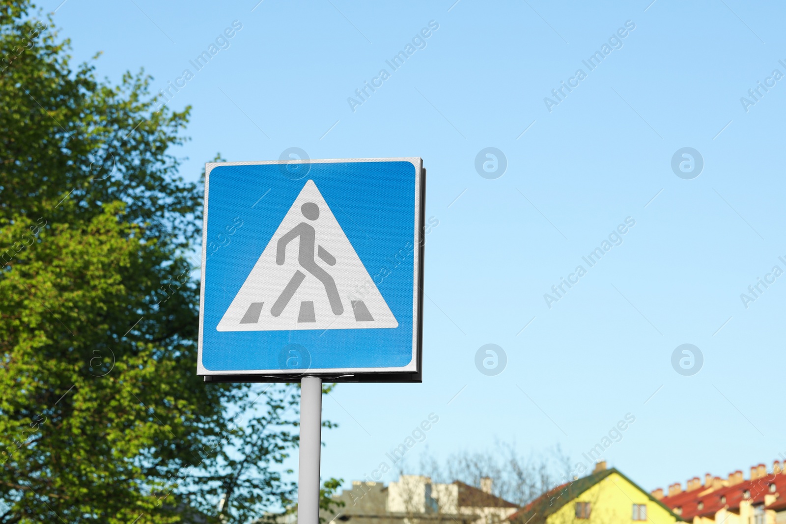 Photo of Post with Pedestrian Crossing traffic sign in city on sunny day