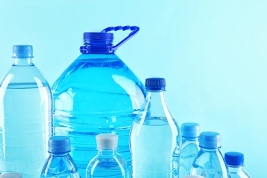 Set of different plastic bottles with pure water on color background